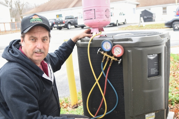Skylands Energy Service technician examining AC refrigerant