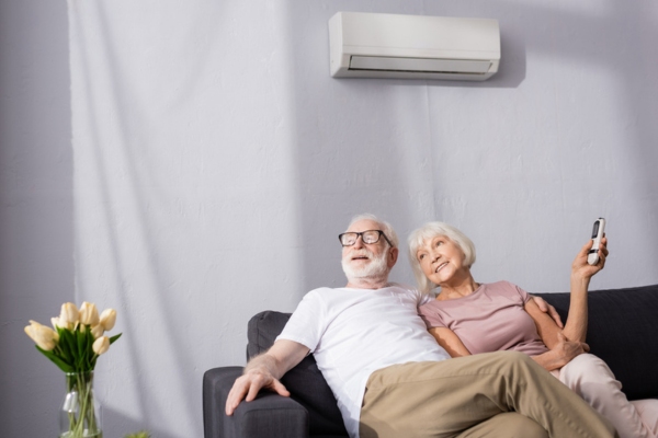 elderly couple enjoying the cool air conditioner while lounging in the couch