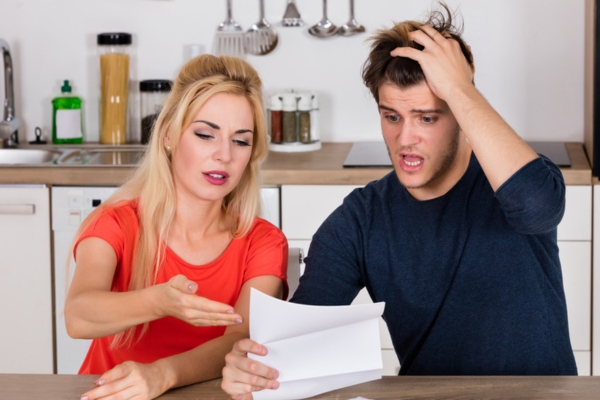 couple looking stressed and shocked after receiving energy bill