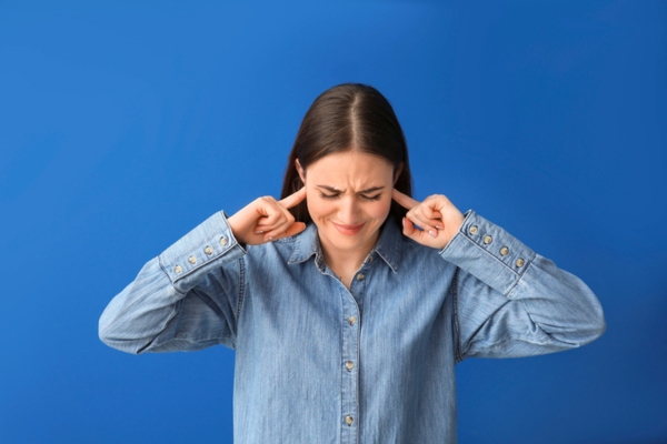 woman covering ears due to noisy HVAC ducts