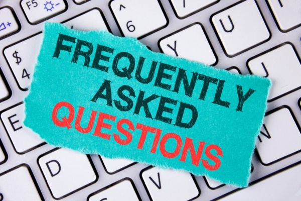 frequently asked questions text on a piece of paper placed on top of a keyboard