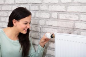 woman turning on home radiator