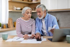 couple looking at utility bills depicting ways to reduce heating bills