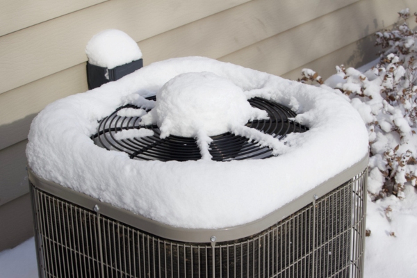 Close up view of new fallen snow on top of an outdoor central heating system