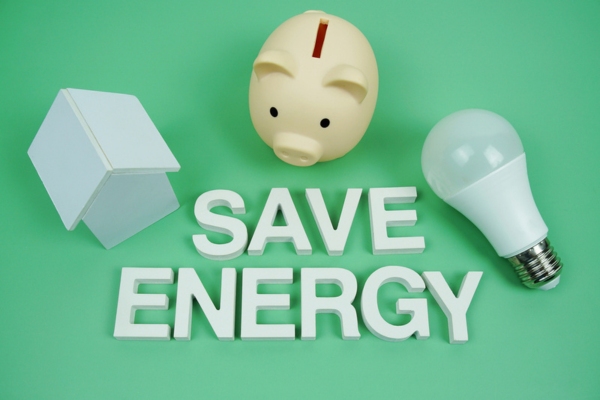 Save Energy alphabet letters with house model, piggy bank and lightbulb depicting energy savings