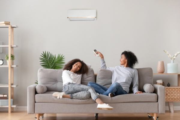 siblings lounging on couch with ductless mini-split heating