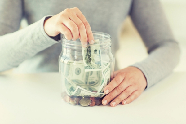 woman saving money in a jar depicting fuel saving tips